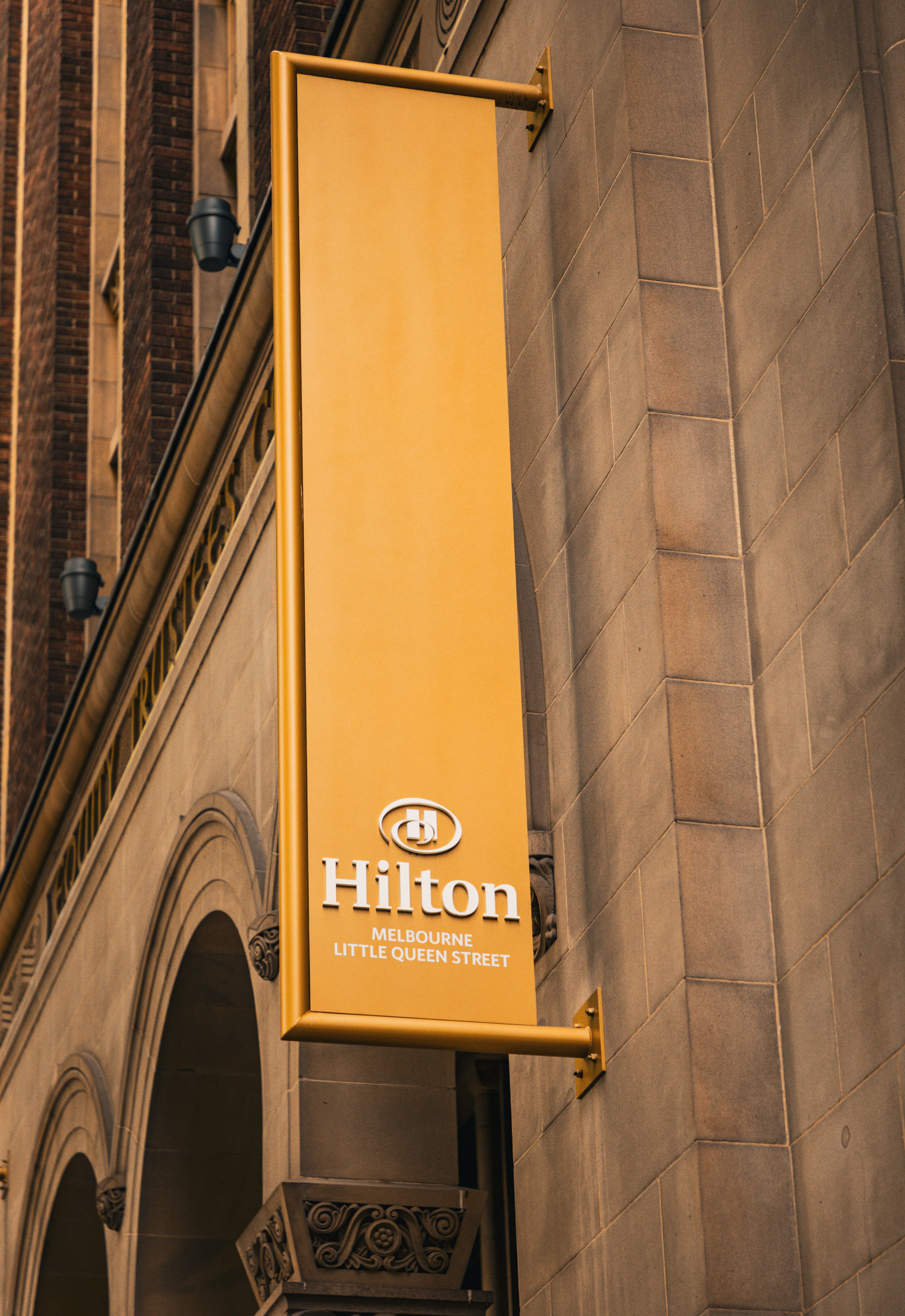 Cartel exterior de acciones Hilton Melbourne Little Queen Street en la fachada del hotel.