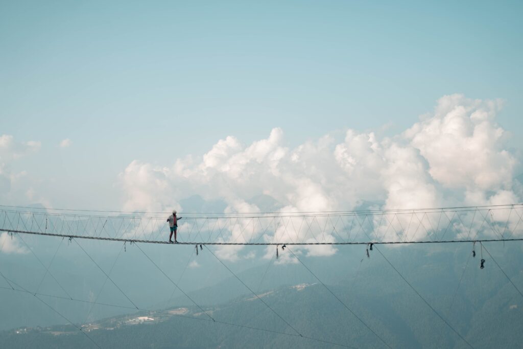 Persona cruzando un puente colgante que representa el riesgo en la inversión en valor