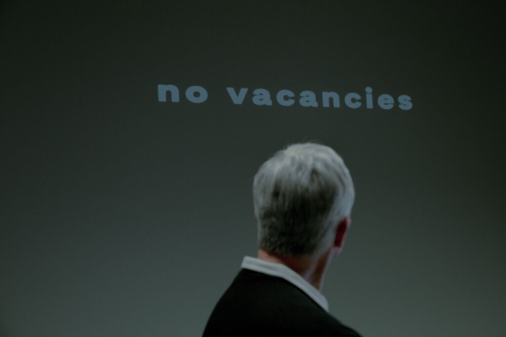 Persona observando un cartel de "no vacancies", representando la incertidumbre en la inversión de Bill Ackman