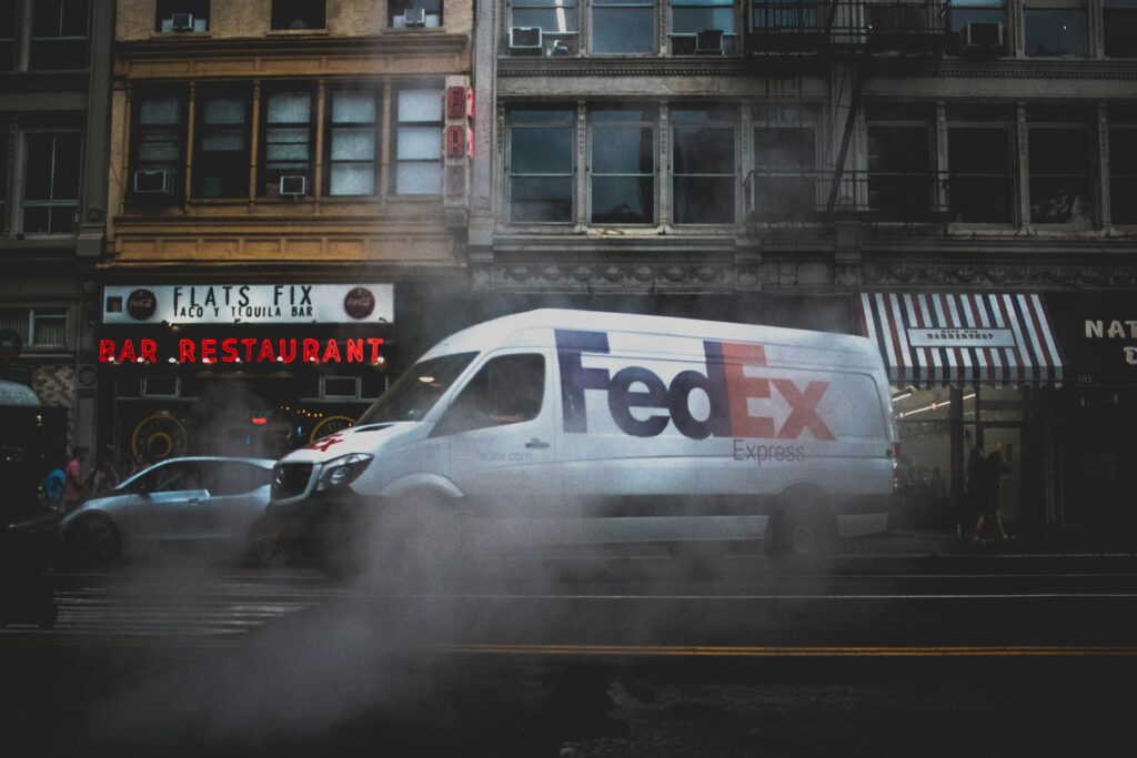 Furgoneta de reparto de acciones FedEx realizando entregas en un entorno urbano