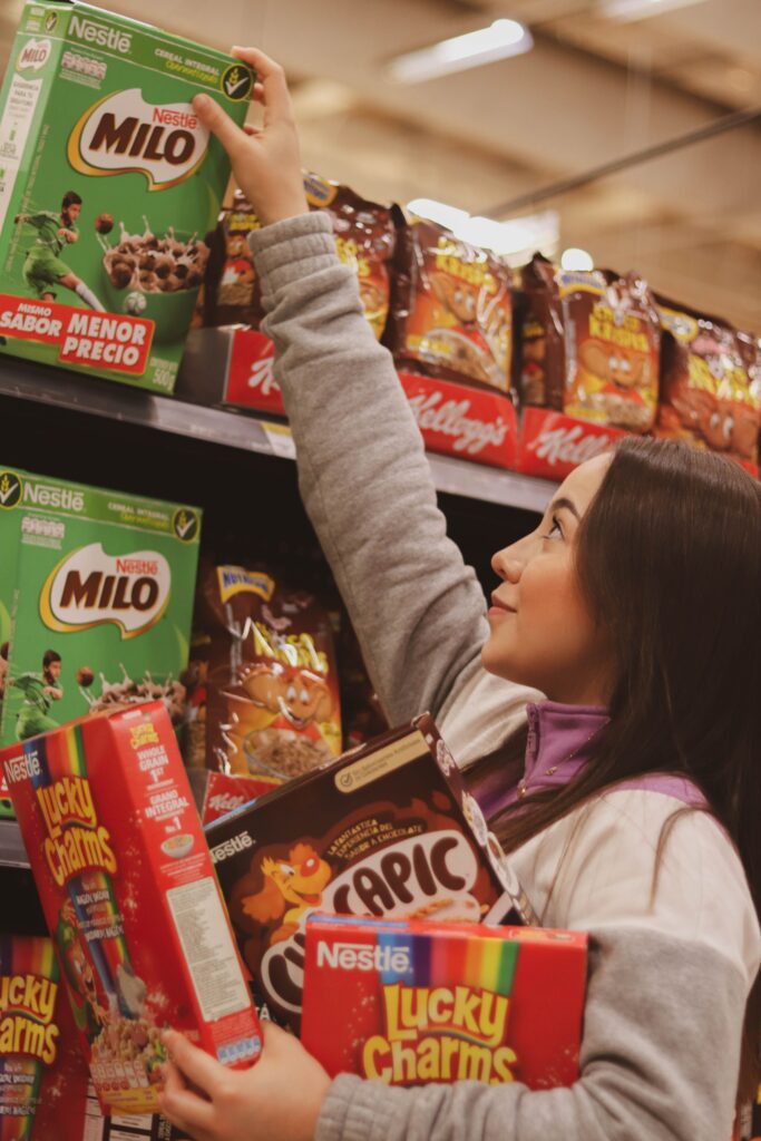 Consumidora eligiendo productos de acciones Nestle en el lineal de un supermercado