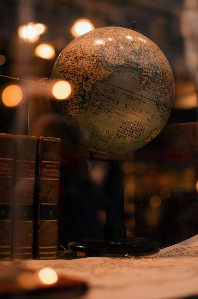 Globo terráqueo sobre una mesa con libros, representando la exploración, la inspiración viajera y la dimensión internacional de Pangea Travel