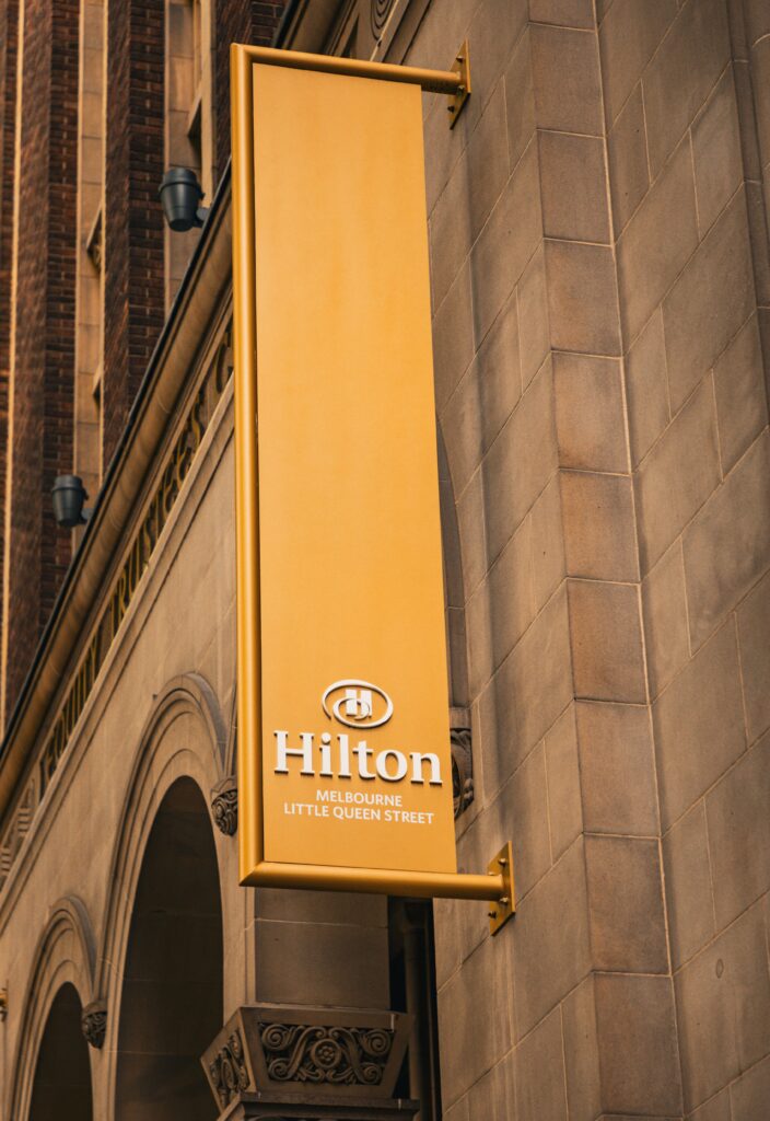 Cartel exterior de acciones Hilton Melbourne Little Queen Street en la fachada del hotel.